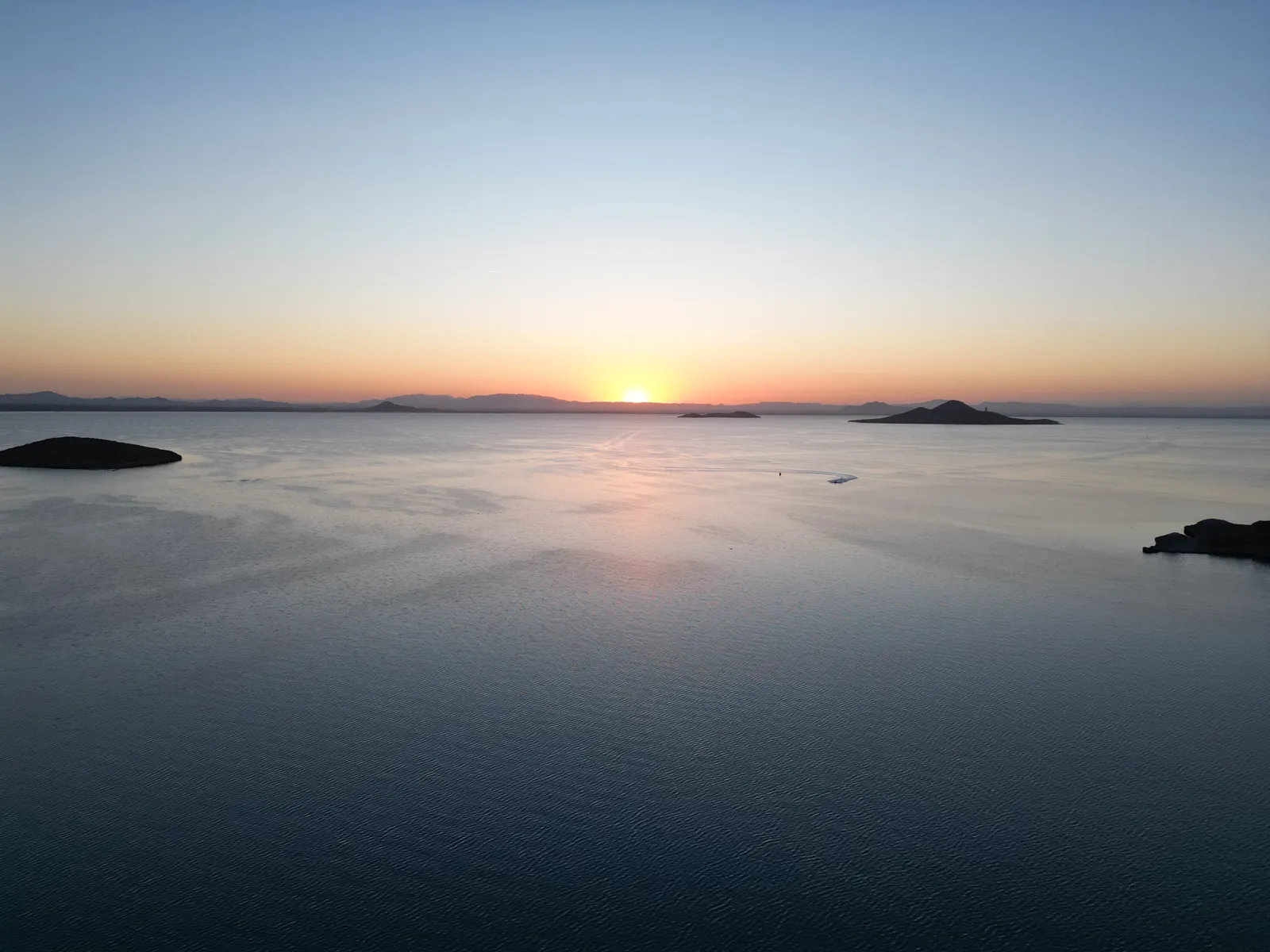Atardecer sereno sobre la laguna desde el dron